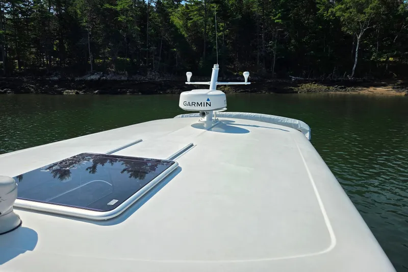 Slide: The Image of 2018 Back Cove 37 boat deck with Garmin equipment, surrounded by lush forest. - 22