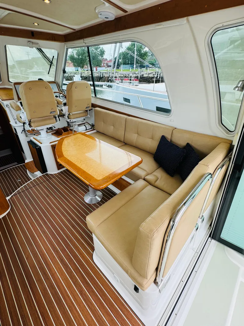 Slide: The Image of Interior of a 2018 Back Cove 37 with beige sofa and wooden table. - 27