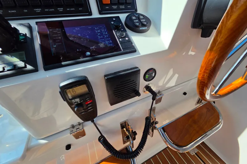Slide: The Image of 2018 Back Cove 37 helm with navigation controls and wooden steering wheel. - 103