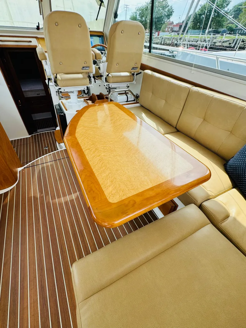 Slide: The Image of Interior of a 2018 Back Cove 37 with beige seating and a wooden table. - 29