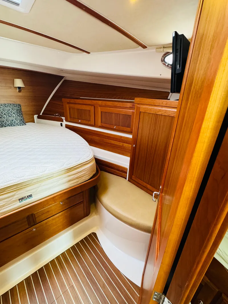 Slide: The Image of The cabin of a 2018 Back Cove 37 with wooden furnishings and a bed. - 34