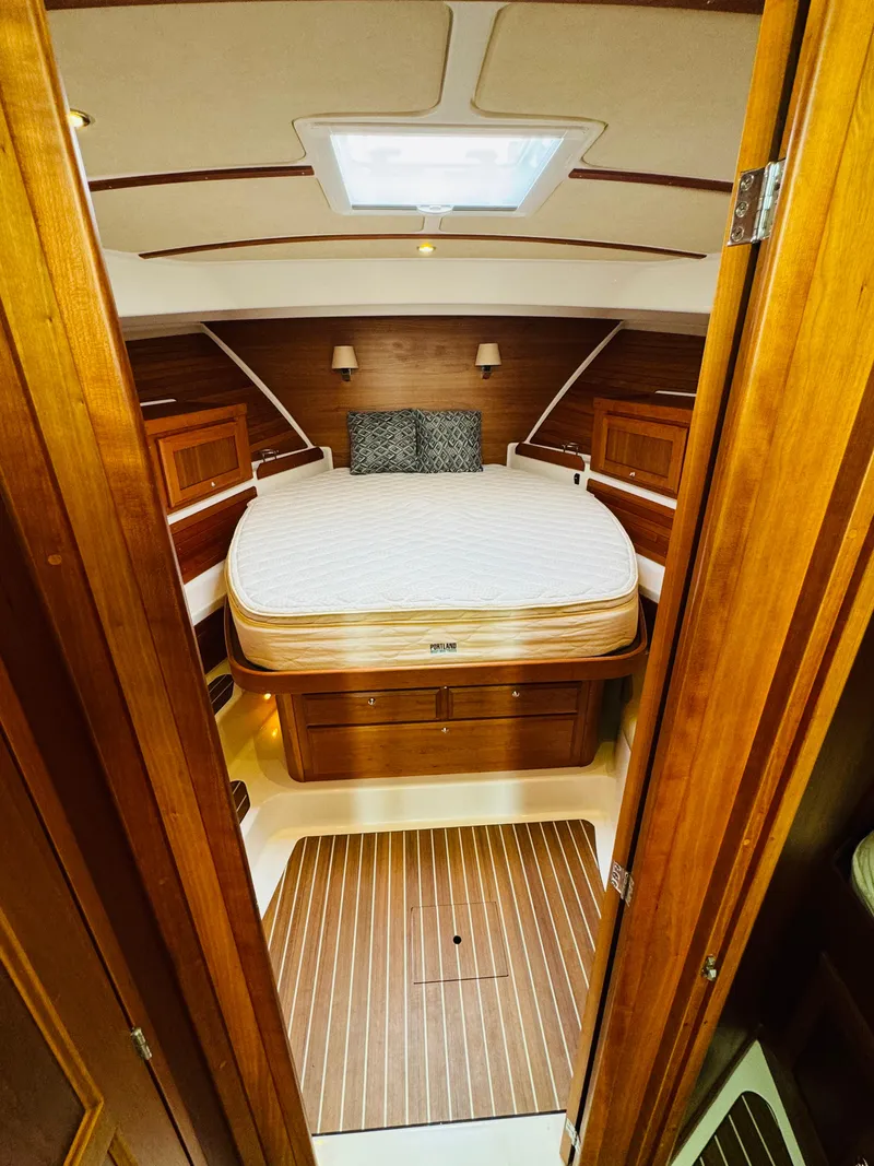 Slide: The Image of The 2018 Back Cove 37 cabin features a cozy bed with wood paneling and skylights. - 32