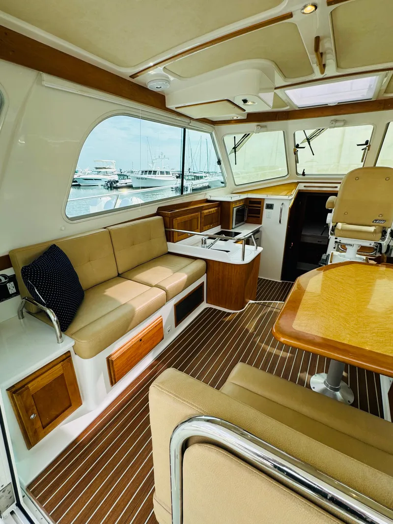 Slide: The Image of Interior of a 2018 Back Cove 37 with beige seating and a wooden table. - 26