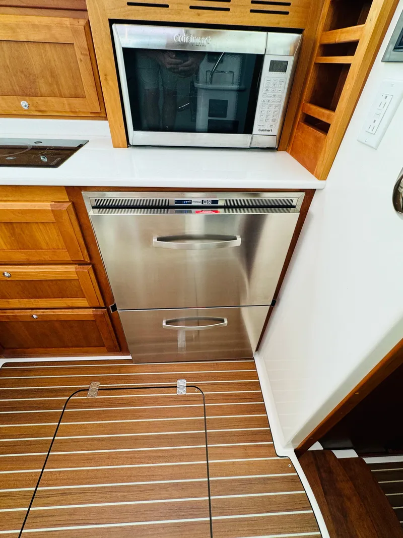 Slide: The Image of The galley of a 2018 Back Cove 37 with a microwave and stainless steel drawers. - 43