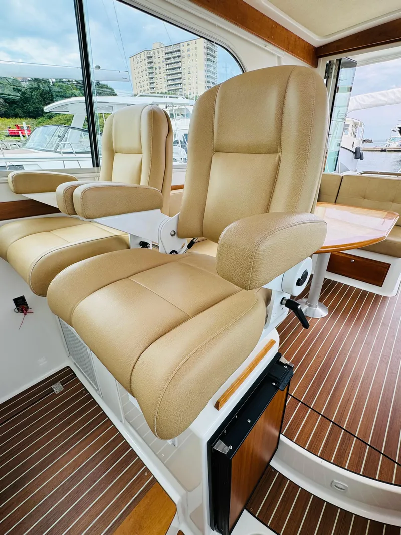 Slide: The Image of Interior of a 2018 Back Cove 37 with beige leather seats and wooden flooring. - 50