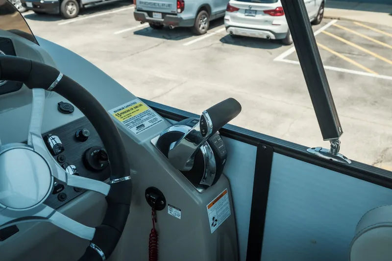 Slide: The Image of 2022 Cypress Cay Seabreeze 252 boat helm with steering wheel and throttle controls. - 16