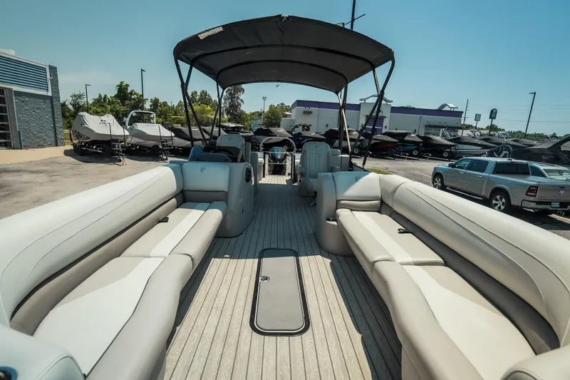 Slide: The Image of 2022 Cypress Cay Seabreeze 252 pontoon boat with spacious seating and canopy in a dealership lot. - 11