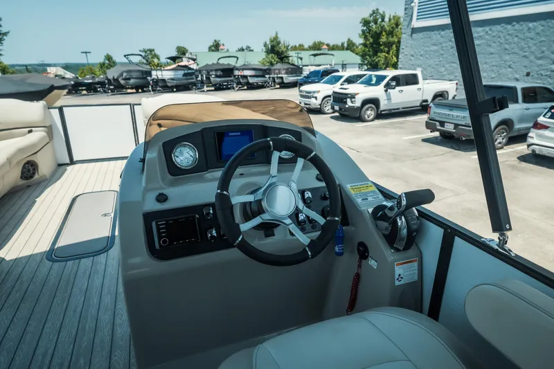 Slide: The Image of 2022 Cypress Cay Seabreeze 252 boat helm with steering wheel and controls. - 25
