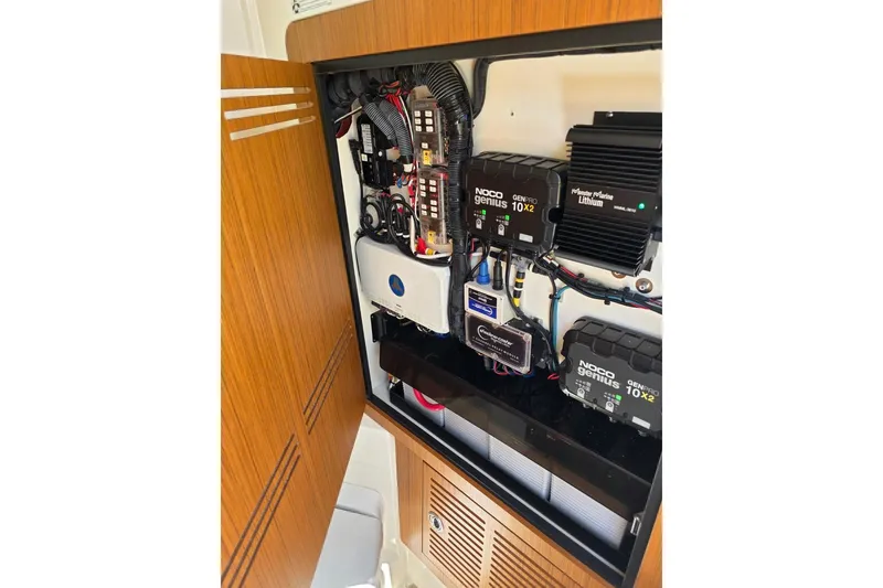 Slide: The Image of Electrical panel inside 2023 Solace 32CS boat, featuring NOCO Genius chargers and lithium battery system. - 13