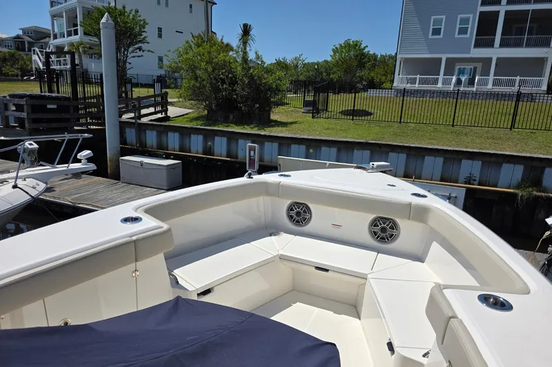 Slide: The Image of 2023 Solace 32CS boat docked, featuring spacious seating and modern design. - 8