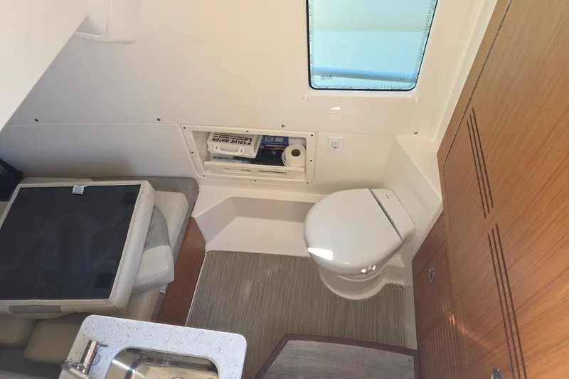 Slide: The Image of 2023 Solace 32CS boat interior with compact bathroom and seating area. - 11