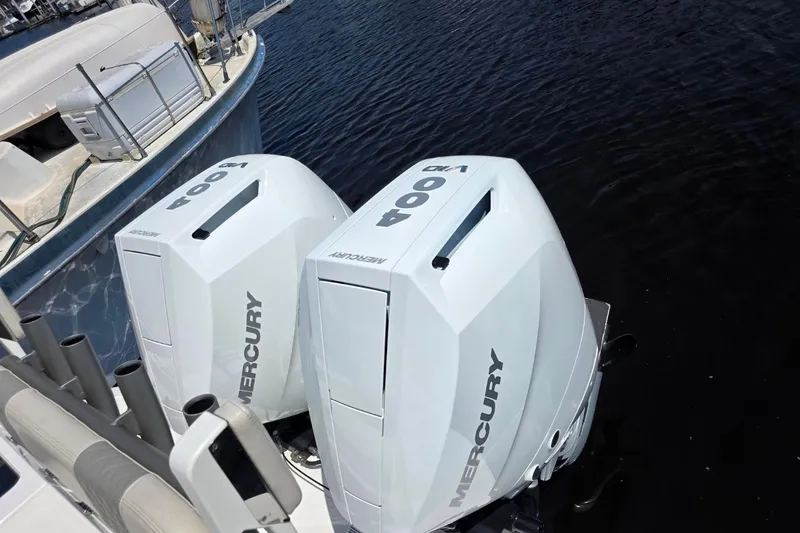 Slide: The Image of Twin Mercury 400 outboard engines on a 2023 Solace 32CS boat, docked by the water. - 21