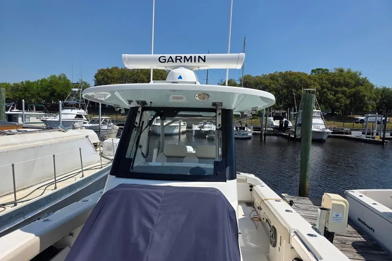 Slide: The Image of 2023 Solace 32CS boat docked, featuring Garmin equipment, in a marina setting. - 9