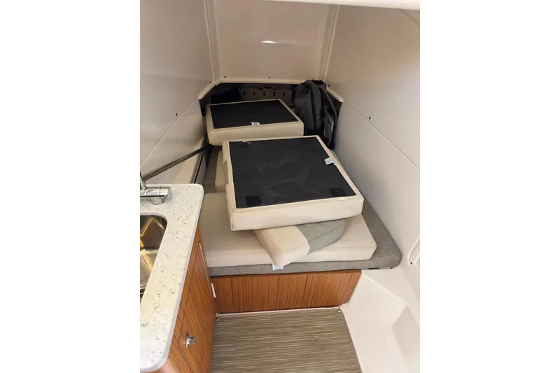 Slide: The Image of 2023 Solace 32CS cabin interior with cushions and compact kitchenette. - 12