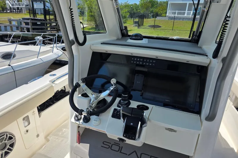 Slide: The Image of 2023 Solace 32CS boat helm with modern controls and steering wheel. - 4