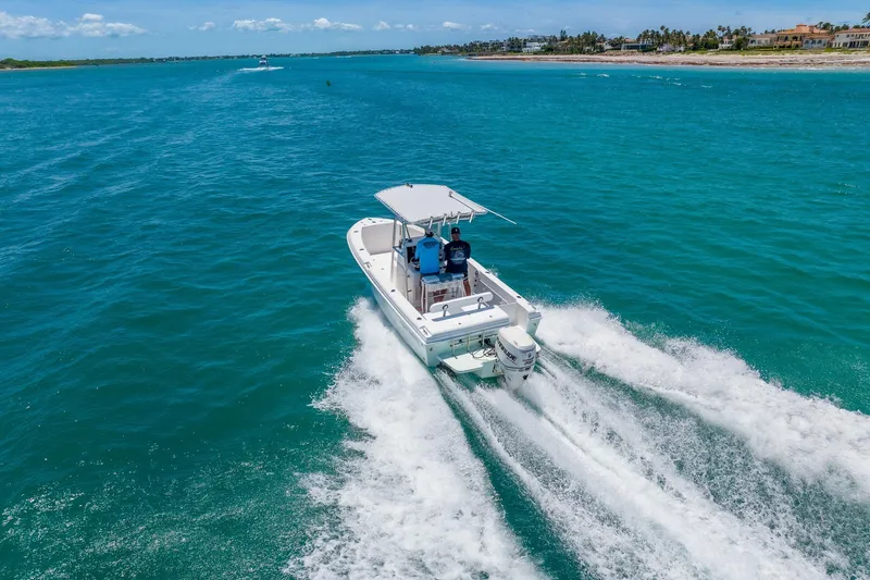 Slide: The Image of 2006 Bluewater 2150 CC boat cruising on clear blue ocean waters. - 5