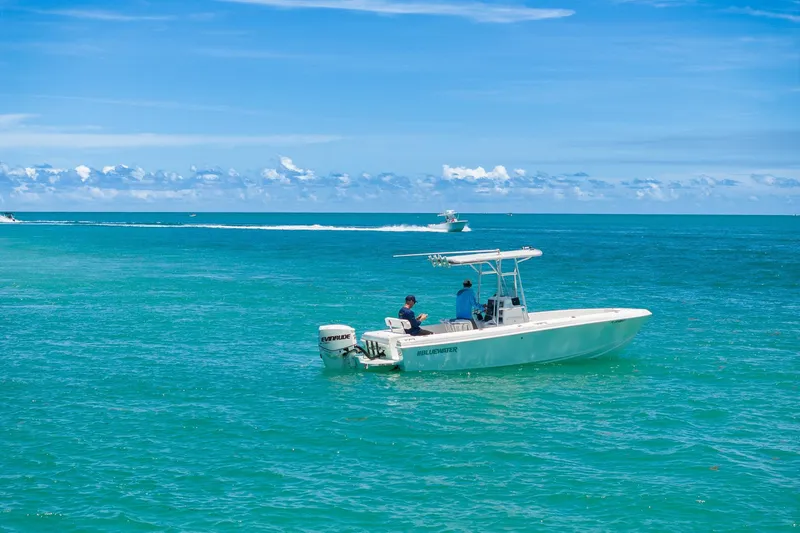 Slide: The Image of 2006 Bluewater 2150 CC boat on turquoise ocean under clear blue sky. - 2