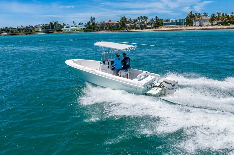Slide: The Image of 2006 Bluewater 2150 CC boat cruising on clear blue ocean near a tropical shoreline. - 6