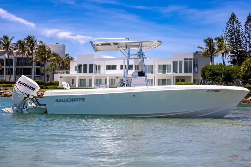Slide: The Image of 2006 Bluewater 2150 CC boat on water, modern buildings and palm trees in background. - 8