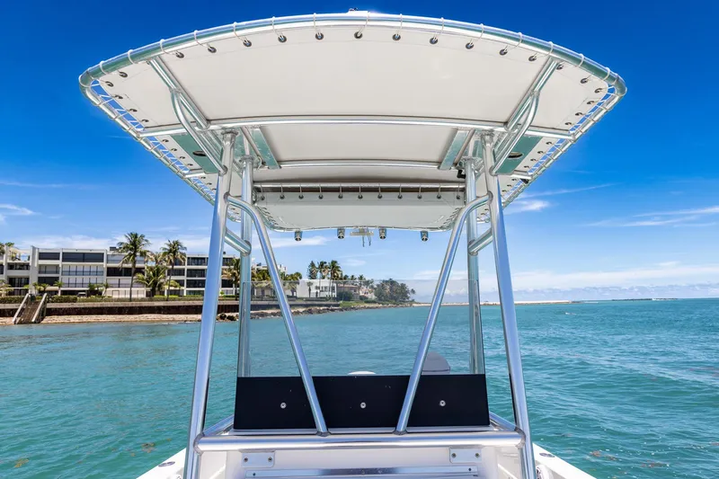 Slide: The Image of 2006 Bluewater 2150 CC boat on clear blue water near coastal buildings. - 29