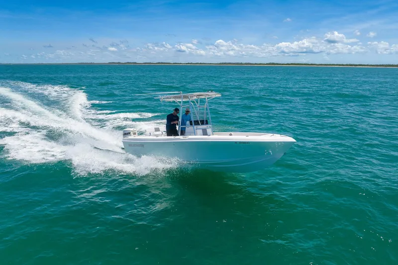 Slide: The Image of 2006 Bluewater 2150 CC boat cruising on clear blue ocean waters under a sunny sky. - 0