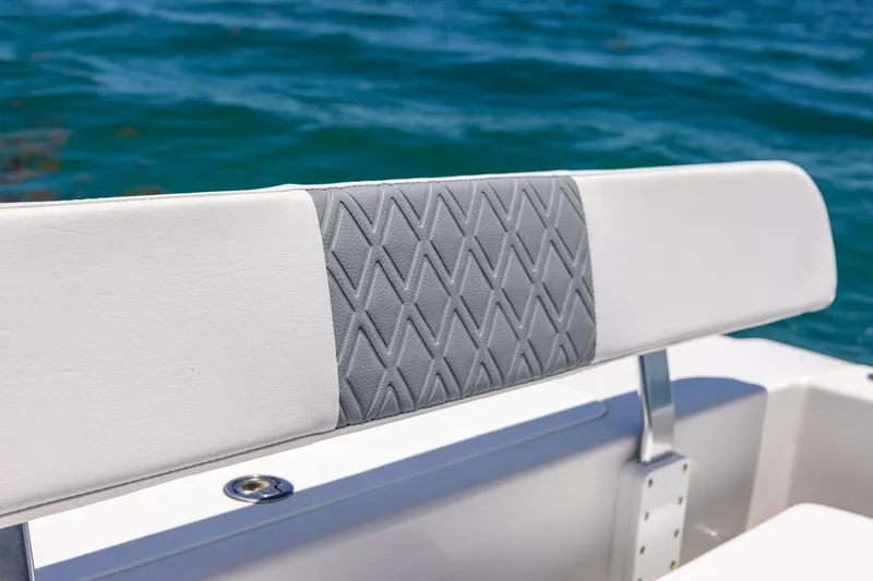 Slide: The Image of White and gray cushioned seat on a 2006 Bluewater 2150 CC boat, with ocean background. - 33