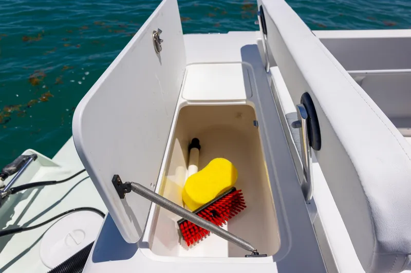 Slide: The Image of Open storage compartment on 2006 Bluewater 2150 CC boat with cleaning supplies. - 28