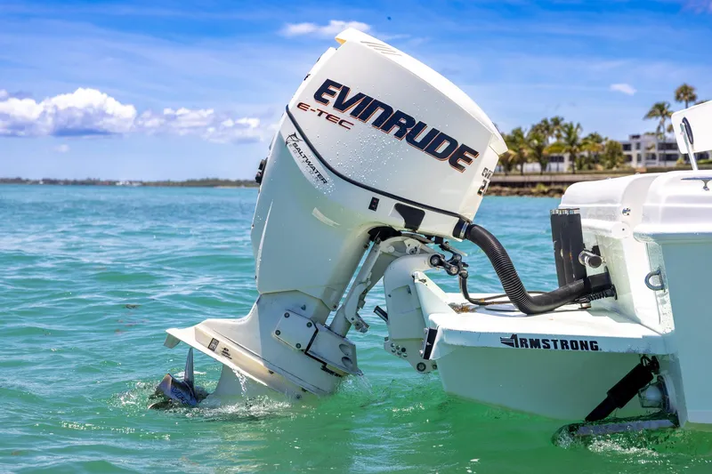 Slide: The Image of 2006 Bluewater 2150 CC boat with Evinrude E-TEC engine in clear blue water. - 13