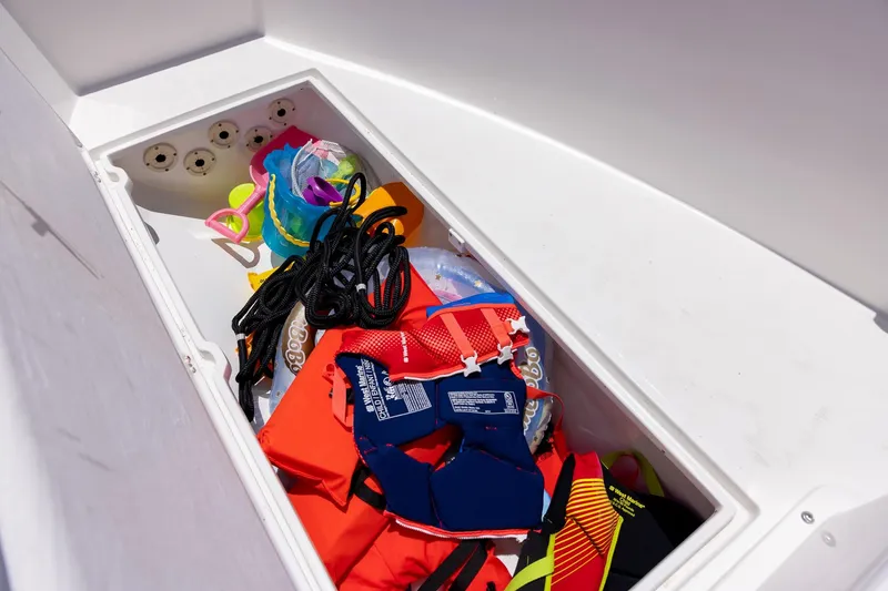 Slide: The Image of Storage compartment on a 2006 Bluewater 2150 CC boat with life jackets and gear. - 37