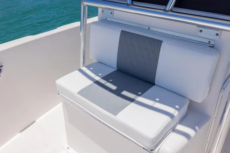 Slide: The Image of White and gray cushioned seat on 2006 Bluewater 2150 CC boat, with ocean backdrop. - 30