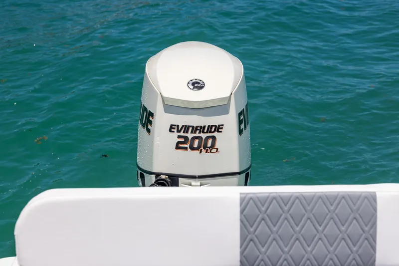 Slide: The Image of Evinrude 200 HP outboard motor on Bluewater 2150 CC, 2006 model, in clear blue water. - 16
