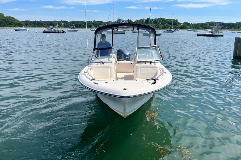 Slide: The Image of 2021 Grady-White Freedom 215 boat on calm water, surrounded by other vessels. - 2