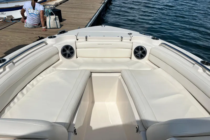 Slide: The Image of 2021 Grady-White Freedom 215 boat interior with white seating, docked by the water. - 24