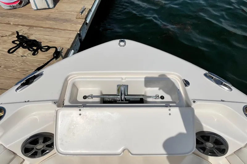 Slide: The Image of Bow of 2021 Grady-White Freedom 215 boat docked, featuring anchor storage and speakers. - 27