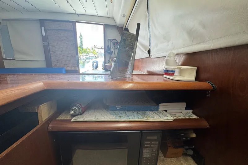 Slide: The Image of Interior of a 1991 Ocean Yachts 35 Super Sport with wooden shelves and nautical charts. - 44