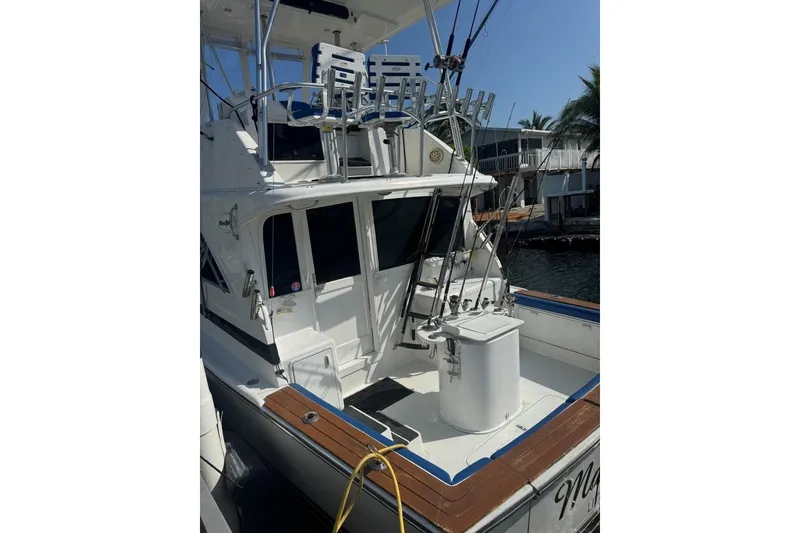 Slide: The Image of 1991 Ocean Yachts 35 Super Sport boat with fishing rods, docked near palm trees. - 4