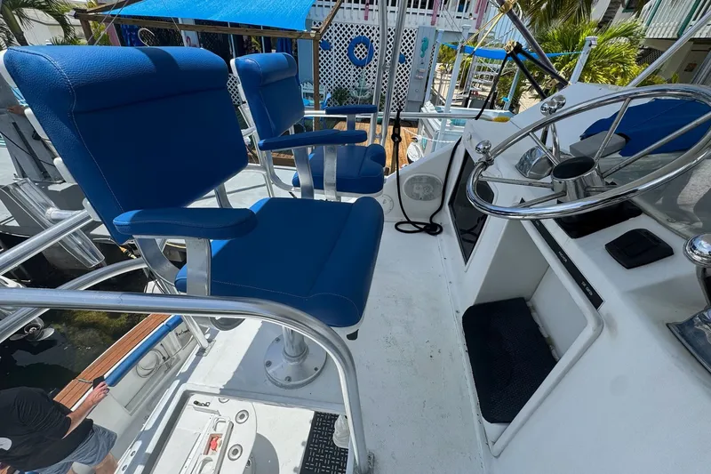 Slide: The Image of 1991 Ocean Yachts 35 Super Sport helm with blue captain chairs and steering wheel. - 12