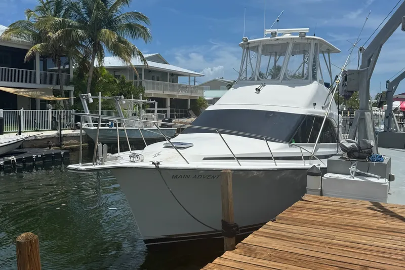 Slide: The Image of 1991 Ocean Yachts 35 Super Sport docked near palm trees and waterfront homes. - 3