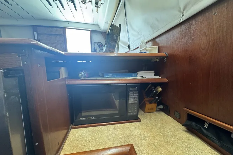Slide: The Image of 1991 Ocean Yachts 35 Super Sport interior with microwave and wooden cabinetry. - 64