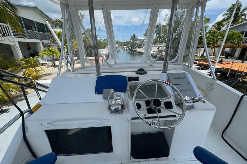 Slide: The Image of 1991 Ocean Yachts 35 Super Sport helm with steering wheel and Garmin navigation, dockside view. - 17