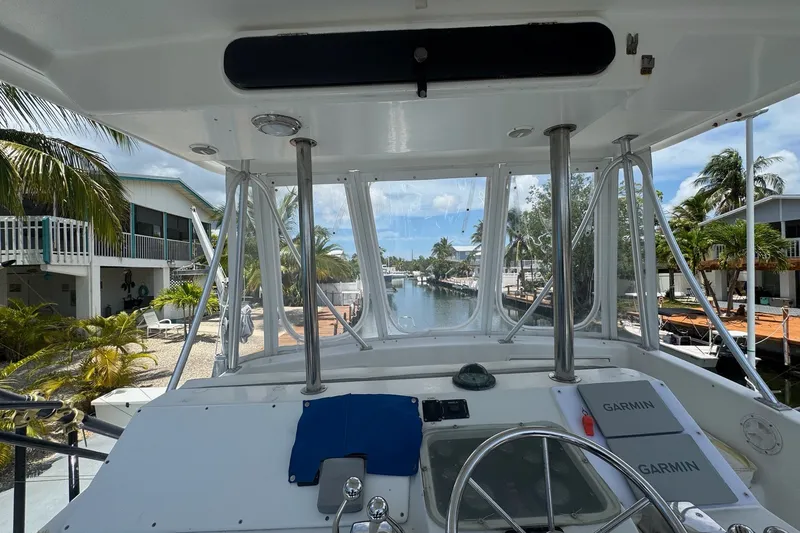 Slide: The Image of Cockpit view of 1991 Ocean Yachts 35 Super Sport, docked near waterfront homes. - 15