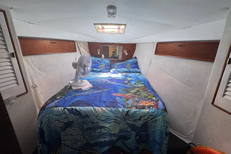 Slide: The Image of Cozy cabin interior of 1991 Ocean Yachts 35 Super Sport with vibrant bedding and fan. - 60