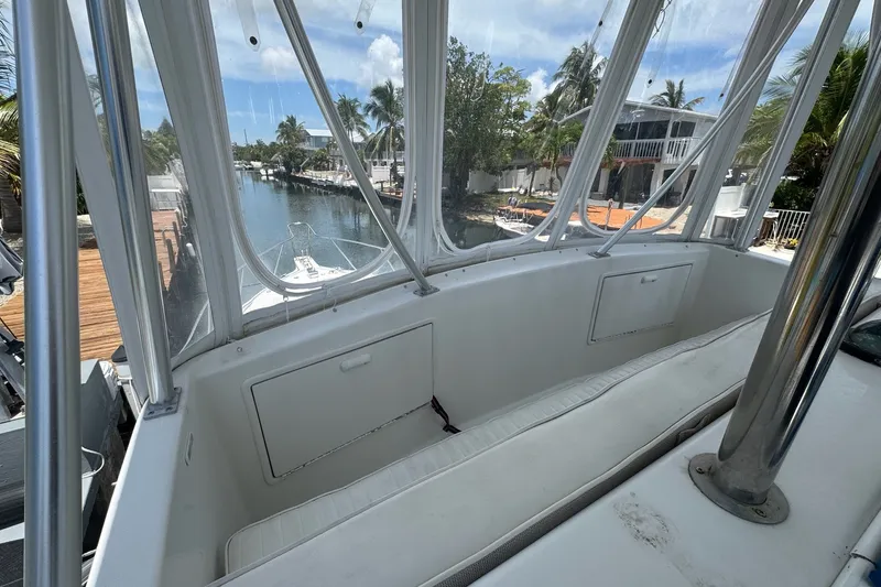 Slide: The Image of 1991 Ocean Yachts 35 Super Sport cockpit with clear enclosure, overlooking a serene waterfront view. - 23