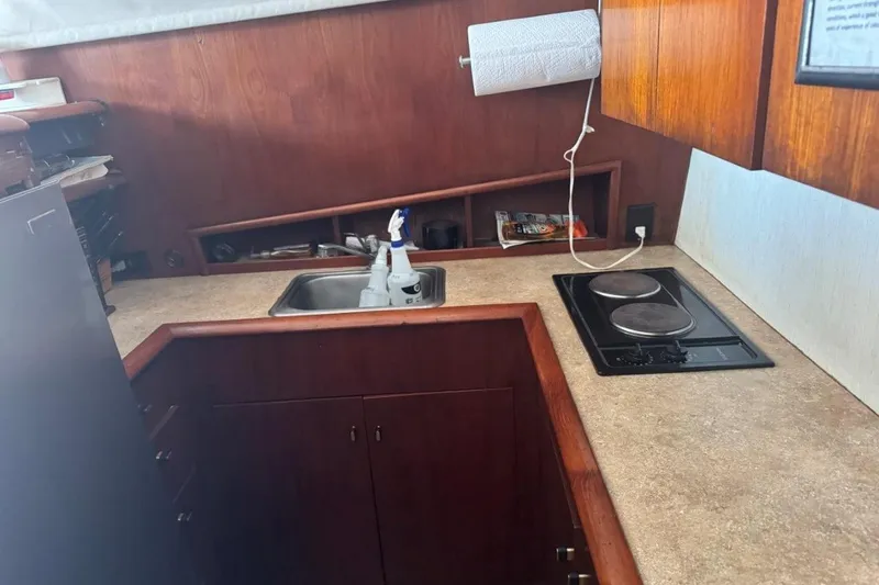 Slide: The Image of 1991 Ocean Yachts 35 Super Sport kitchen with sink, stove, and wooden cabinetry. - 5
