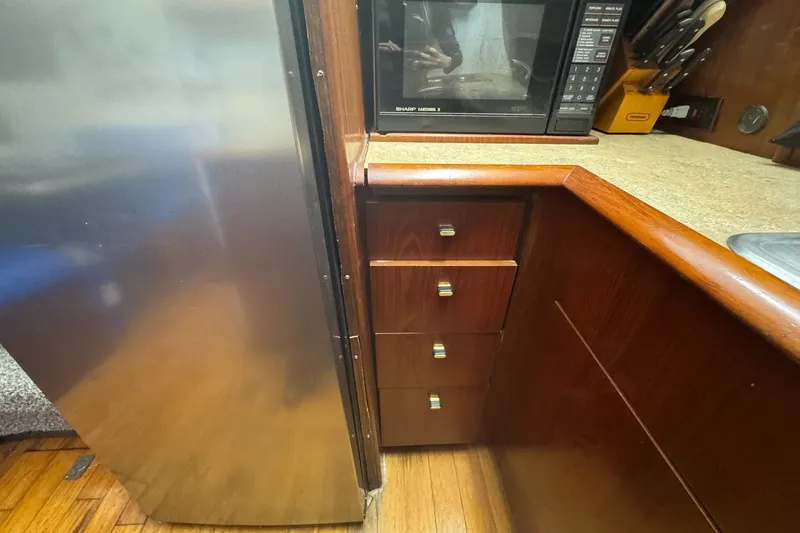 Slide: The Image of Interior of 1991 Ocean Yachts 35 Super Sport kitchen with microwave and wooden cabinetry. - 41