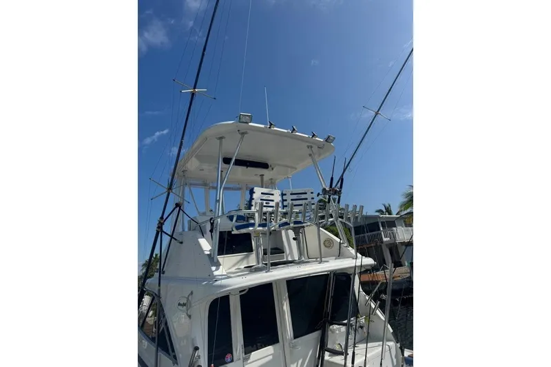 Slide: The Image of 1991 Ocean Yachts 35 Super Sport boat with fishing rods and tower under clear blue sky. - 6