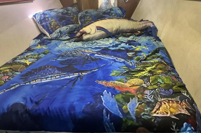 Slide: The Image of Nautical-themed bedding in a 1991 Ocean Yachts 35 Super Sport cabin, featuring vibrant marine life. - 8