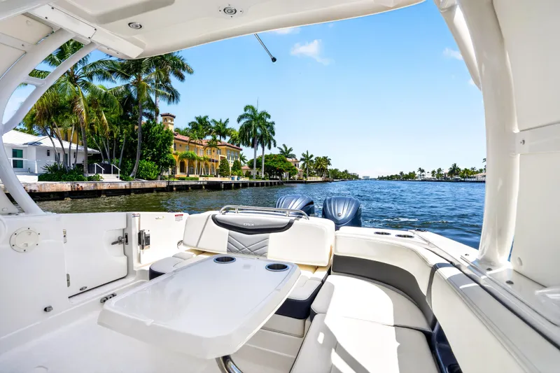 Slide: The Image of 2023 Chaparral 280 OSX boat interior with waterfront view and palm trees. - 69
