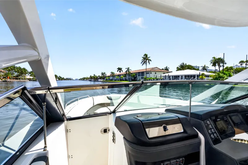 Slide: The Image of 2023 Chaparral 280 OSX boat interior with waterfront view and palm trees. - 78