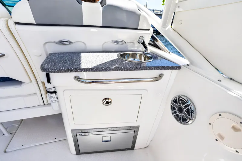 Slide: The Image of 2023 Chaparral 280 OSX boat interior with sink, countertop, and storage. - 25